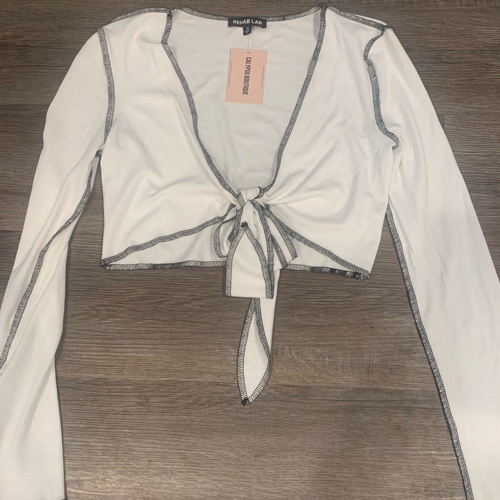 Divided white crop wrap top with black detail stitching. NWT—M